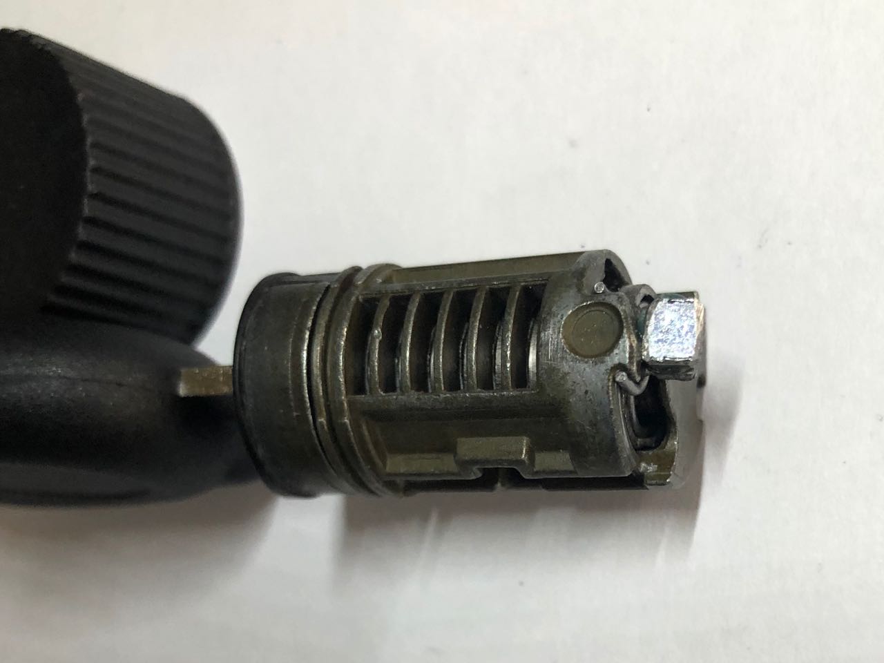 La patte supérieure du ressort de rappel bien positionnée